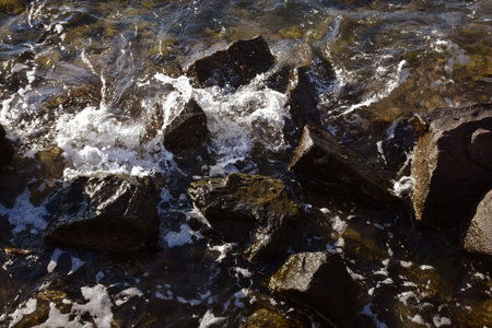Water flowing over the rocks in the sea at sunset. natural backgroundの写真素材