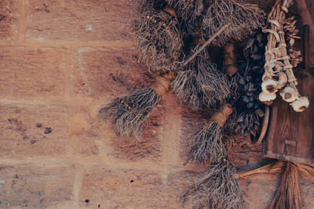 Close-up of beautiful dry leaves, herbs, dried garlic on the stone wall. Wallpaper suitable for...