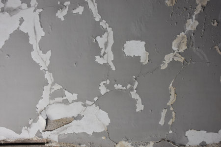 Old gray wall with peeling paint. Grunge background.
