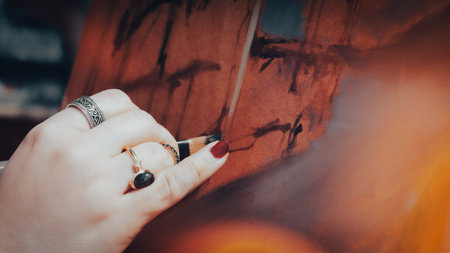 Close-up of a woman's hand painting a picture in the studioの写真素材