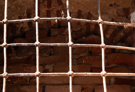 Old iron bars on the brick wall as a background. textureの写真素材
