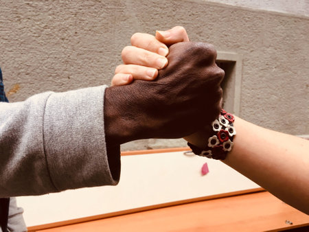 Close up of hands of a black man and a white woman.