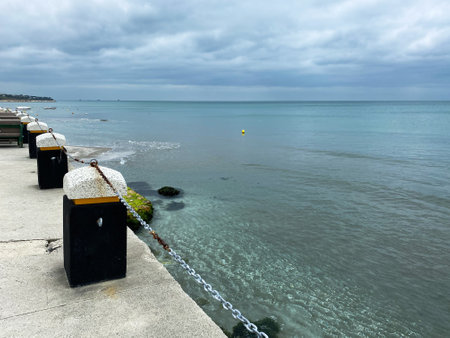 Seascape with a breakwater and a yellow buoy in the foregroundの写真素材