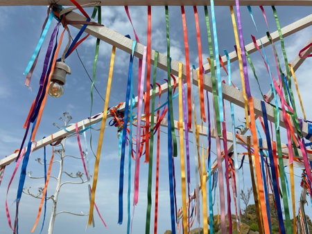 Colorful ribbons tied to a metal pole with blue sky backgroundの写真素材