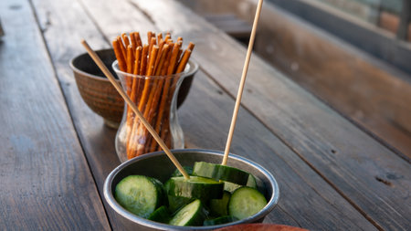 Cucumber salad with grissini sticks on a wooden tableの写真素材