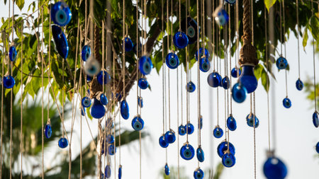 Blue evil eye beads hanging with a rope from a tree branch. Traditional Evil Eye Amulet. A national symbol and guardian in Turkey. The background is blurred.の写真素材