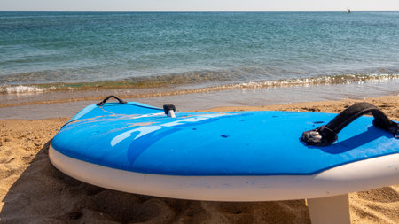 Paddle board (surfboard) on a sandy beach with a sea background
