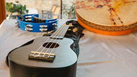 Ukulele, bendir and tambourine on a table in a restaurant. Selective focus.の写真素材