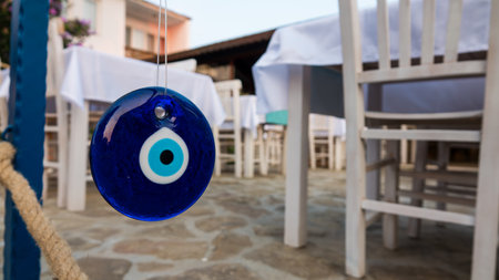 Blue eyes from the evil eye - amulet hung as an ornament in front of restaurant tablesの写真素材