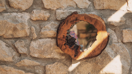 Mirror with wooden frame hung on a stone wall. Selective focus.の写真素材