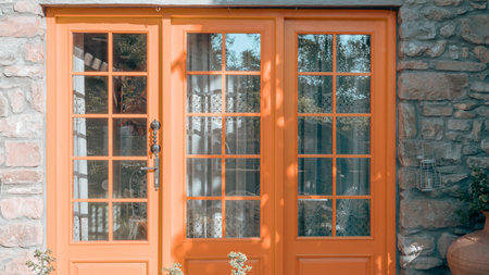 orange wooden door with glass in the backyard of a country houseの写真素材