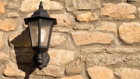Vintage street lamp on stone wall background. Selective focus.の写真素材