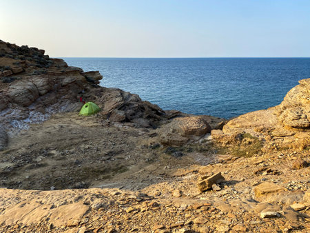 A man sitting on a rock on the seashore in Cyprusの写真素材