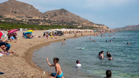 Gokceada, Canakkale, Turkey, August 20, 2023: People swim and sunbathe on the beach of Ugurlu, Secret Liman. Gokceada is a seaside resort in Turkey.のeditorial素材