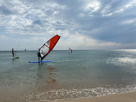Gokceada, Canakkale Turkey September 9, 2023; Wind surfers enjoying the Aegean sea and the wind in Gokceada Kefalos bay against the clear sky. Imbros Island.のeditorial素材