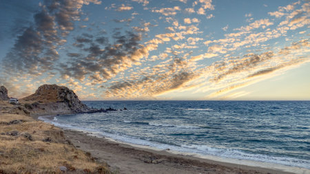 cloud Cluster in sunset sky on a deserted beach with magnificent cliffs and sea waves
