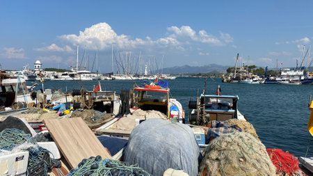 Urla, Izmir, Turkey Sept. 10,2023 Moored fishing boats at the port marina with luxury yachts...