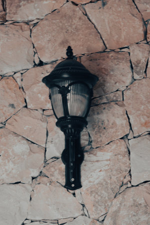 Vintage street lamp on a stone wall. Retro style photo.の写真素材