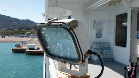 View from the side of a ferry boat in the Aegean Sea, Large powerful ship lighting lantern on the ship deck. Close-up of the big lantern on the cruise shipの写真素材