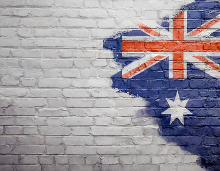 National flag of Australia on brick wall background. Vintage style toned pictureの素材