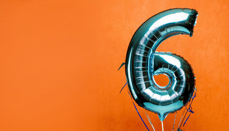 Number 6 silver balloon on orange background. Birthday or anniversary celebration.の素材