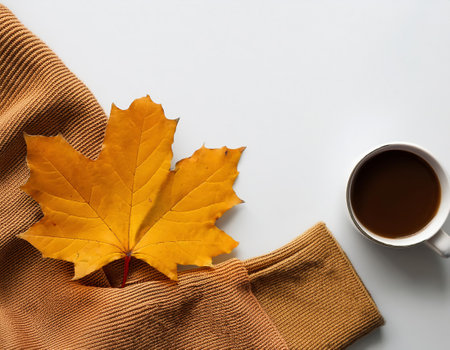 Autumn composition. Cup of coffee, scarf and maple leaf on white background. Flat lay, top view, copy spaceの素材