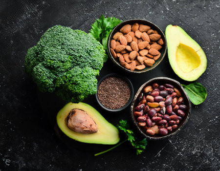 Healthy food clean eating selection: avocado, spinach, broccoli, chia seeds, almond, flax seeds on black backgroundの素材