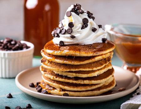 Stack of pancakes with whipped cream and chocolate chips. Selective focus.の素材