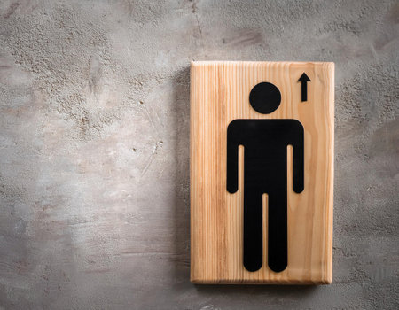 Restroom sign on wooden board on grey textured background, top viewの素材