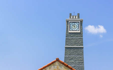 Clock tower with roof  on blue skyの写真素材