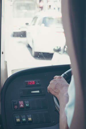 Man's hand of a driver on steering wheel of a bus.の写真素材
