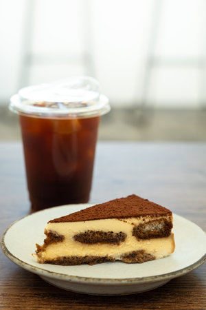 Ice coffee and tiramisu cake on wooden table.の写真素材