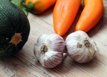 Garlic, zucchini and pepper on a wood tableの写真素材