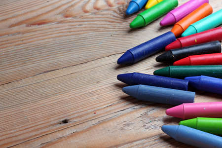 Oil pastel crayons lying on a wooden tableの写真素材