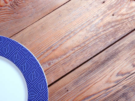 Blue plate lying on a wooden tableの写真素材