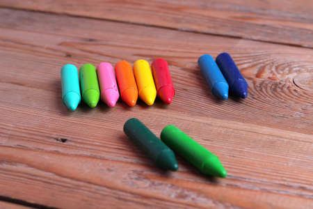 Multicolored crayons lying on a wooden tableの写真素材