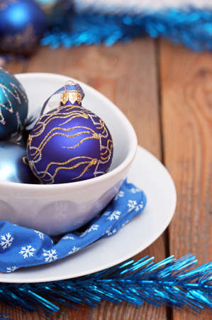 Christmas decorations with balls, white plates and blue napkinの写真素材