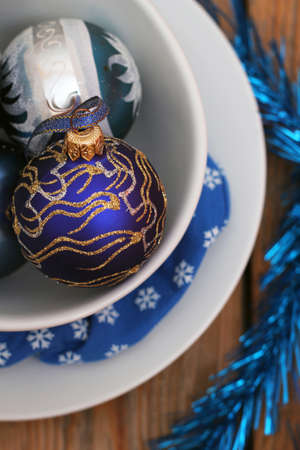 Christmas decorations with balls, white plates and blue napkinの写真素材