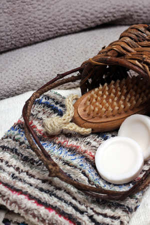 Spa essentials in a basket including olive and honey soaps, towels, wash cloths, brush. Selective focusの写真素材