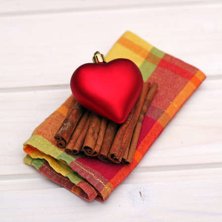 Christmas decorations with heart, cinnamon and napkin on a wooden table. Selective focusの写真素材