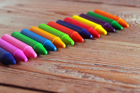 Oil pastel crayons lying on a wooden table. Selective focus. Copy space backgroundの写真素材