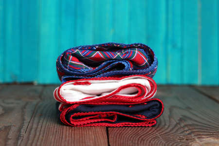 Stack of women's panties lying on a wooden table with bright turquoise backgroundの写真素材