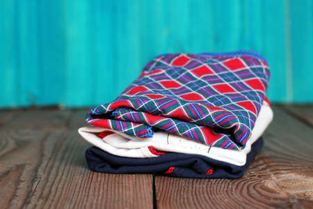 Stack of women's panties lying on a wooden table with bright turquoise backgroundの写真素材