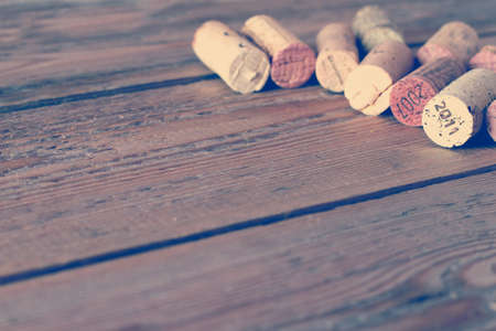 Wine corks lying on a wooden table. Vintage style, toned image. Selective focus. Copy space backgroundの写真素材