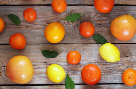 Beauty and health, food and drink, diet and nutrition concept. Citrus fruits (orange, lemon, tangerine) lying on a wooden table. Top view, selective focus, copy space backgroundの写真素材