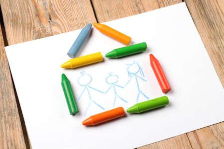 Home, love, family, still life concept. Crayons lying on a paper with children's drawing family. Selective focus, copy space backgroundの写真素材