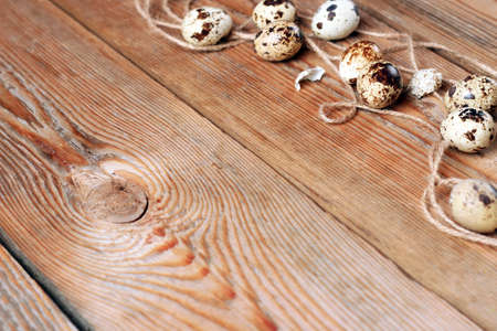 Quail eggs and a rope lying on a wooden table. Selective focus, copy space easter backgroundの写真素材