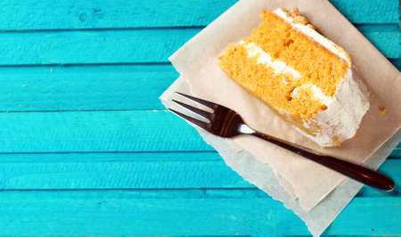 Still life, food and drink concept. Carrot cake with fork on a blue wooden table. Selective focus, copy space backgroundの写真素材