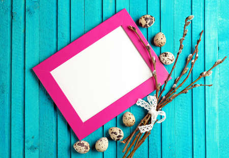 Happy easter concept. Quail eggs and willow branch on a wooden background. Selective focus. Copy  space noteの写真素材