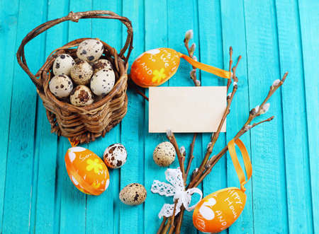 Happy easter concept. Quail eggs and willow branch on a wooden background. Selective focus. Copy ...